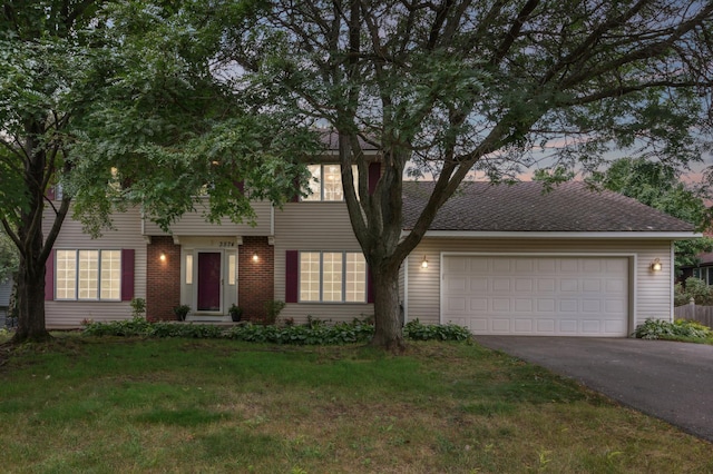 view of front facade with a garage, a front yard, brick siding, and driveway