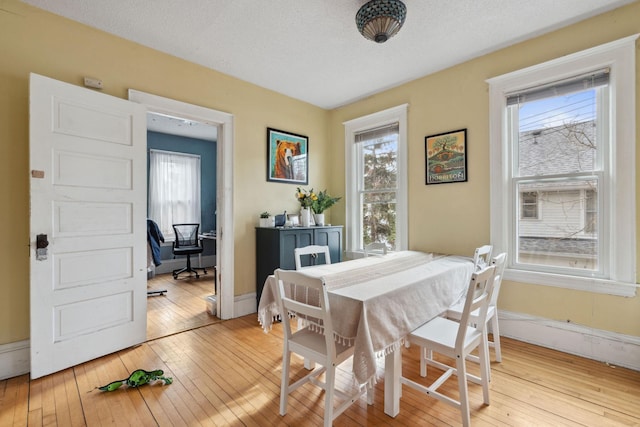 dining space featuring light wood-type flooring and a wealth of natural light