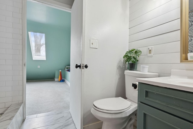 full bathroom with marble finish floor, vanity, toilet, and walk in shower