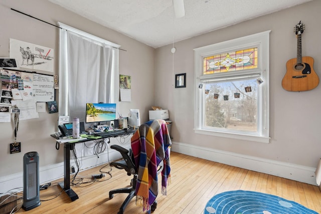 office with wood-type flooring, baseboards, and a textured ceiling