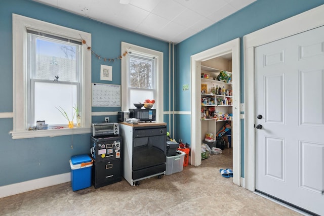 recreation room with a toaster and baseboards