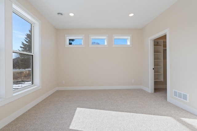 carpeted spare room featuring recessed lighting, visible vents, and baseboards