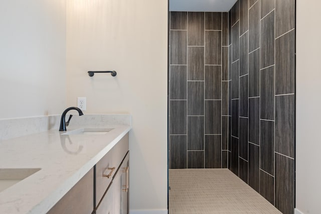 full bath with double vanity, a tile shower, and a sink