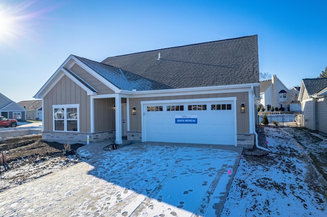 view of front of house with a garage, fence, driveway, roof with shingles, and board and batten siding