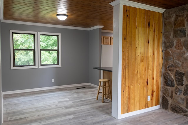 interior space featuring visible vents, light wood-style flooring, ornamental molding, wooden ceiling, and baseboards