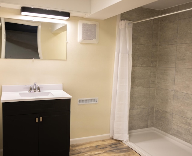 full bath with baseboards, visible vents, wood finished floors, vanity, and a shower stall