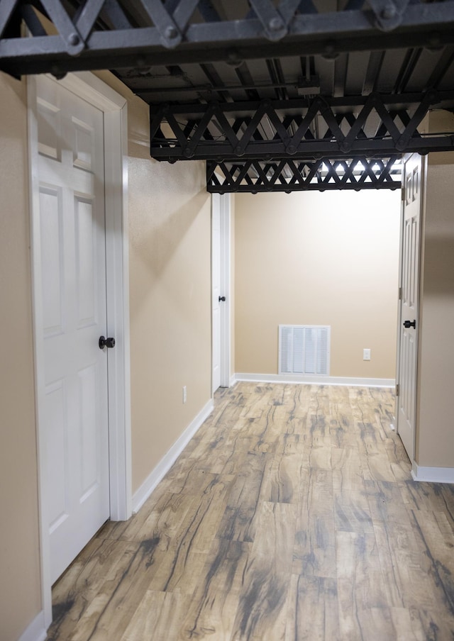 below grade area featuring wood finished floors, visible vents, and baseboards