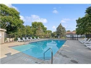 community pool with a patio and fence