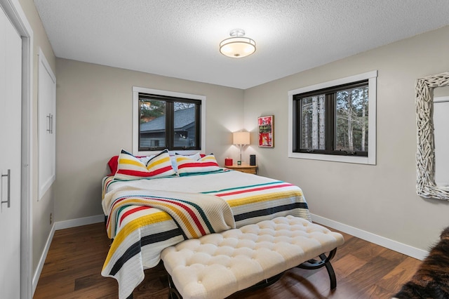 bedroom with a textured ceiling, baseboards, and wood finished floors