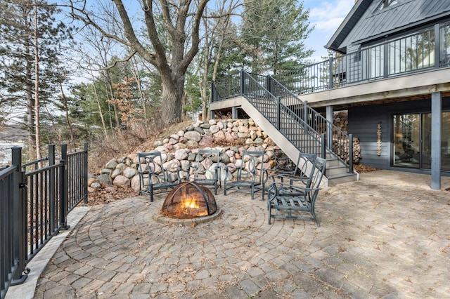 view of patio / terrace with a deck, an outdoor fire pit, and stairway