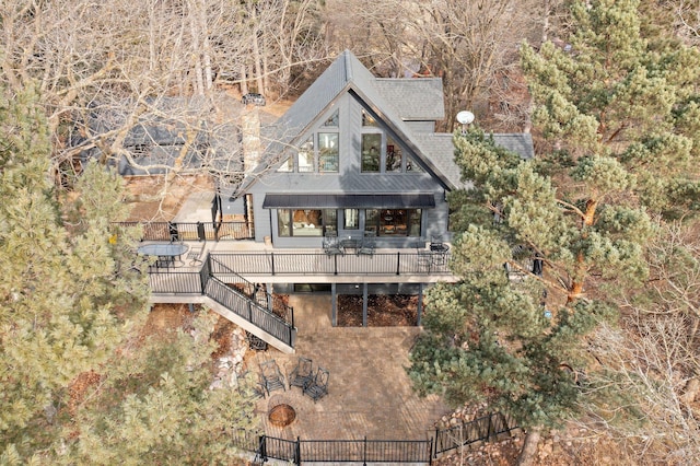 rear view of house featuring stairway, a deck, and roof with shingles