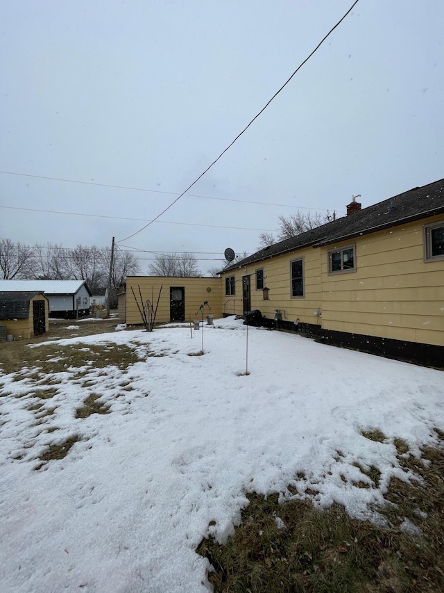 snow covered house with an outbuilding