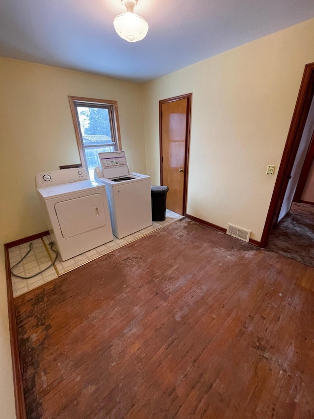 washroom featuring wood-type flooring, visible vents, separate washer and dryer, laundry area, and baseboards