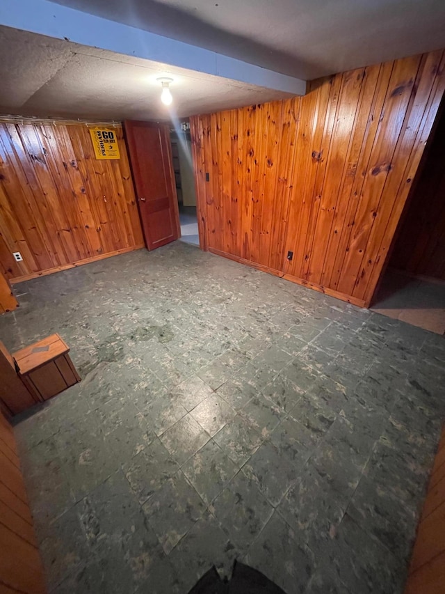 interior space featuring baseboards, a wall unit AC, tile patterned floors, and wooden walls