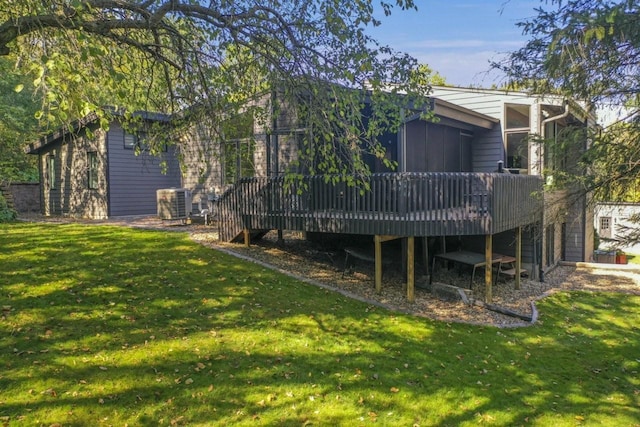 rear view of house featuring a deck, central AC unit, and a yard