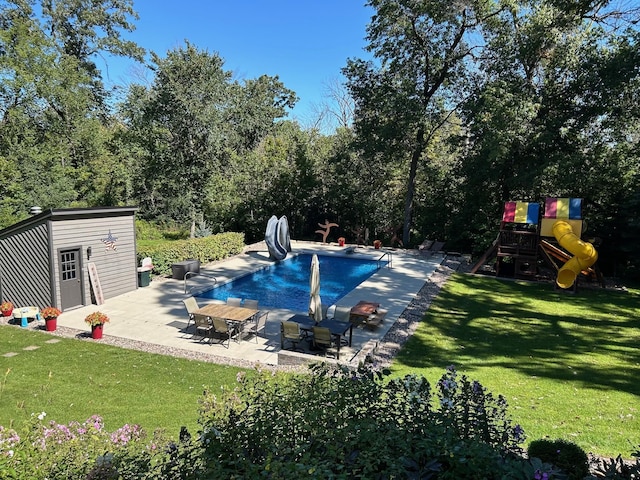 outdoor pool featuring a playground, a yard, and a patio area