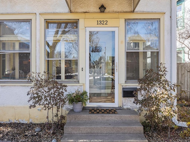 view of exterior entry featuring stucco siding