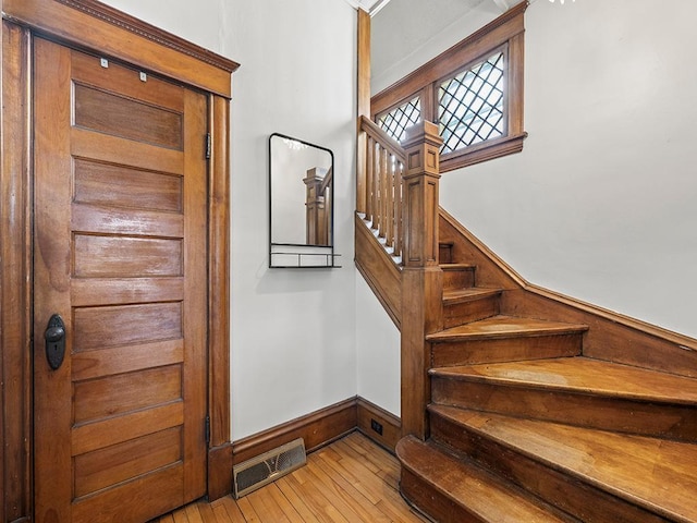 stairway with visible vents and hardwood / wood-style flooring