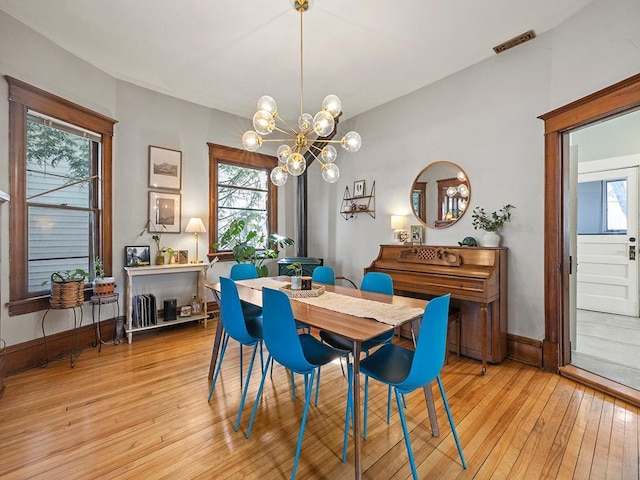 dining room with light wood-style floors, visible vents, a wealth of natural light, and baseboards