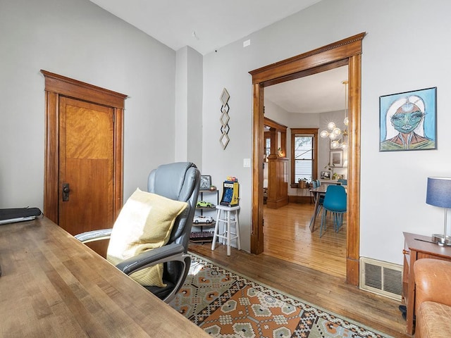 office with visible vents, wood finished floors, and a chandelier