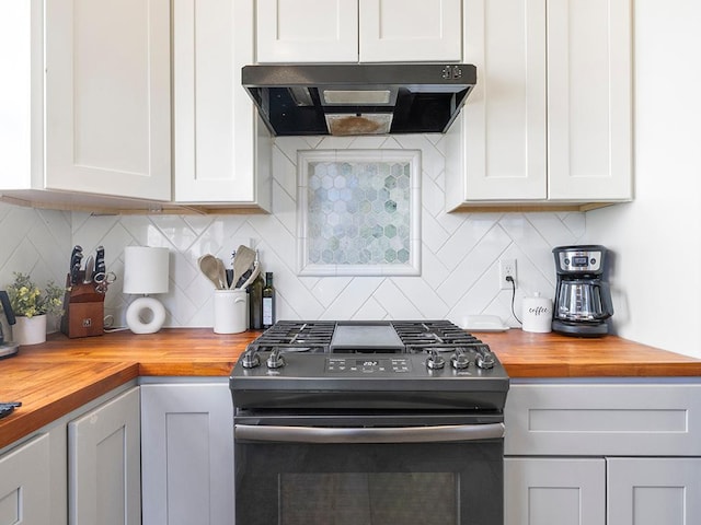 kitchen with wooden counters, backsplash, range hood, white cabinets, and gas range