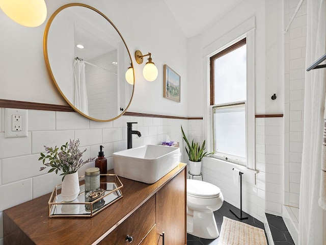 full bathroom with vanity, wainscoting, tile walls, toilet, and tile patterned floors