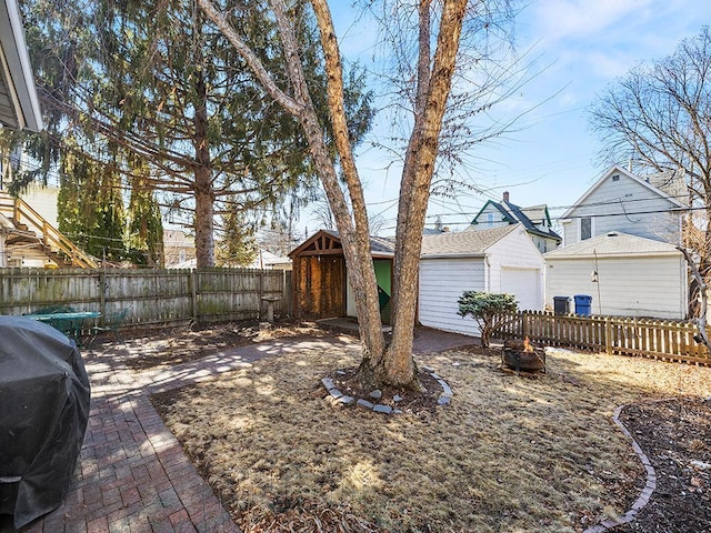 view of yard with an outdoor structure, a fenced backyard, and a patio area