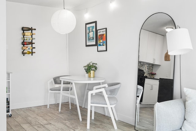 dining room with light wood-type flooring and baseboards