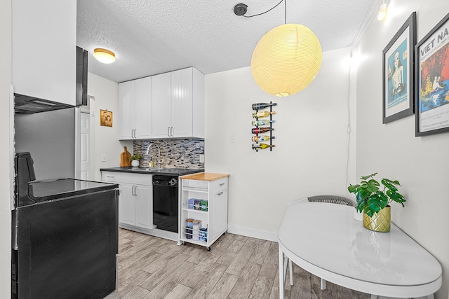 kitchen featuring light wood finished floors, tasteful backsplash, electric stove, a textured ceiling, and white cabinetry