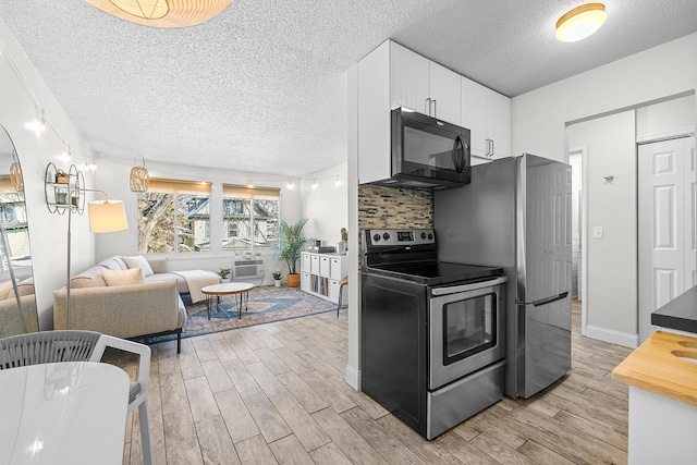 kitchen with stainless steel appliances, backsplash, wood tiled floor, and white cabinetry