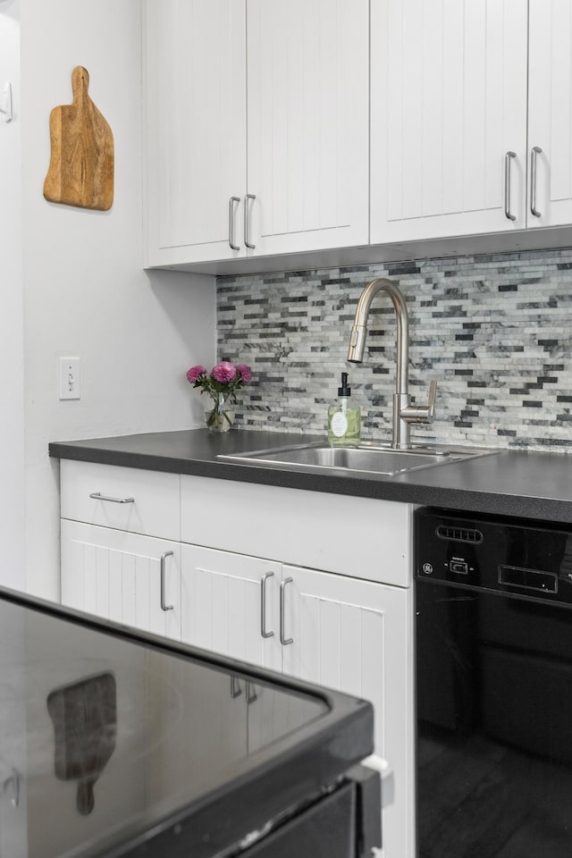 kitchen featuring a sink, dark countertops, backsplash, white cabinetry, and dishwasher