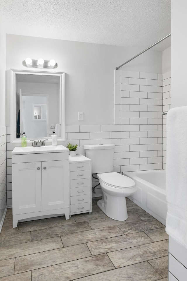 full bathroom with a textured ceiling, tile walls, shower / bathtub combination, and wood tiled floor