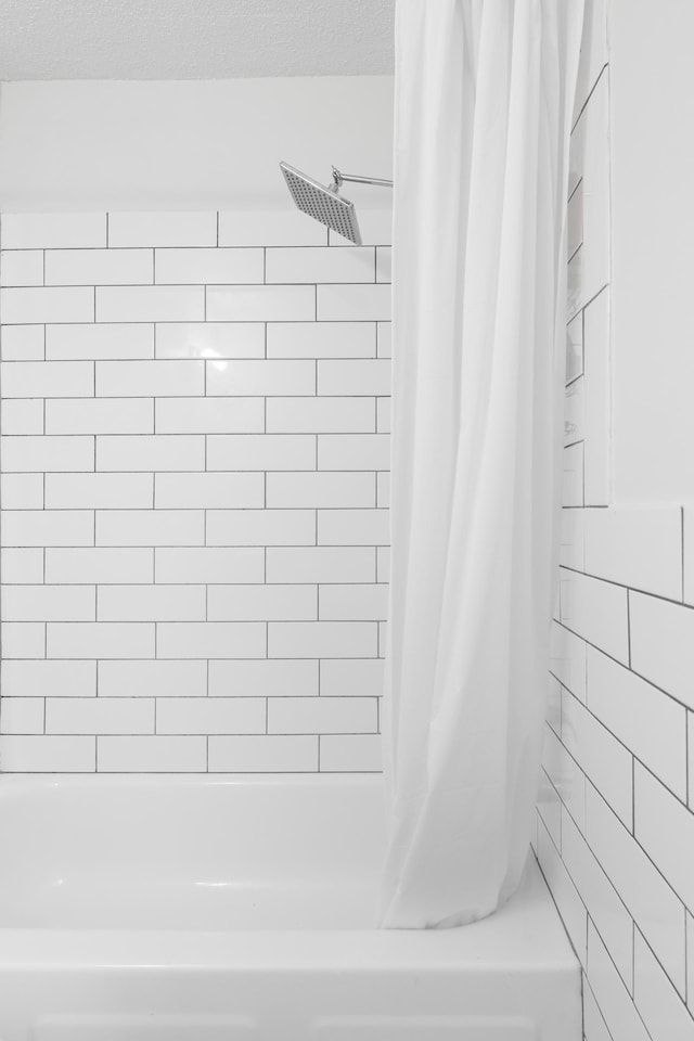 bathroom featuring shower / bathtub combination with curtain and a textured ceiling