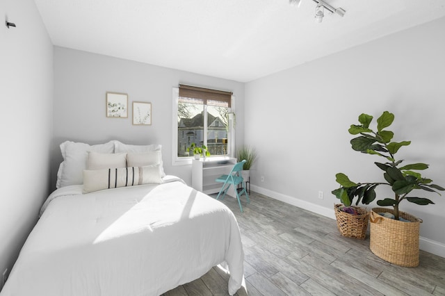 bedroom featuring baseboards and wood finished floors