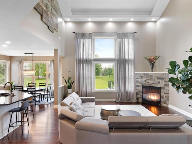 1757 Sandbar Cir, Waconia, MN 55387 - living room with dark wood-style flooring, a stone fireplace, a towering ceiling, and baseboards