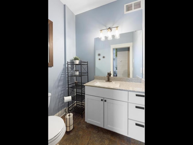 1757 Sandbar Cir, Waconia, MN 55387 - bathroom featuring baseboards, vanity, toilet, and stone finish floors