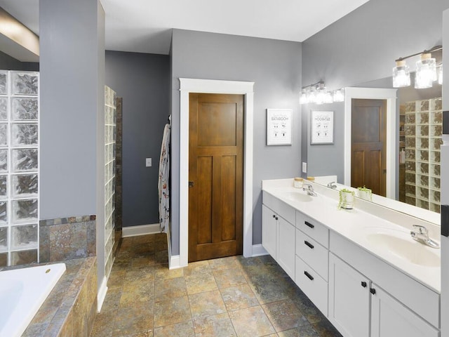 1757 Sandbar Cir, Waconia, MN 55387 - bathroom with stone tile flooring, baseboards, double vanity, a bath, and tiled shower