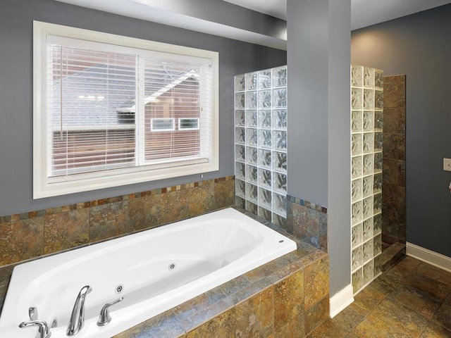 1757 Sandbar Cir, Waconia, MN 55387 - bathroom with a jetted tub, baseboards, and stone finish floors