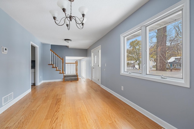 entrance foyer featuring stairway, light wood-type flooring, visible vents, and baseboards