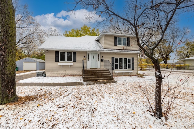 view of front of house featuring an outbuilding, a detached garage, and fence