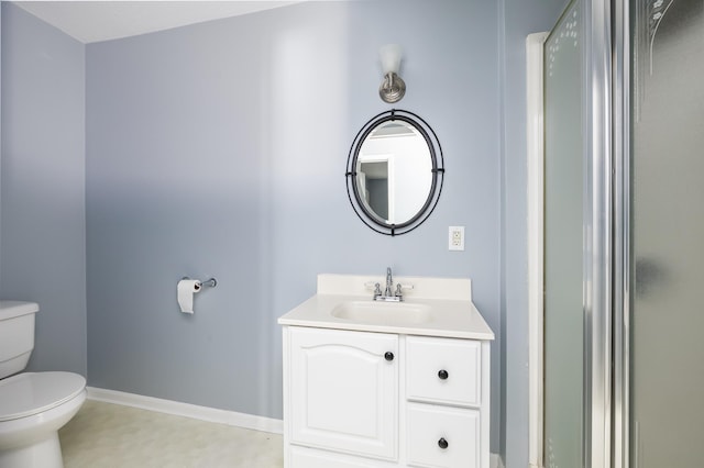 bathroom featuring baseboards, vanity, and toilet