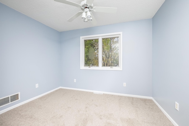 unfurnished room featuring carpet floors, baseboards, visible vents, and a textured ceiling