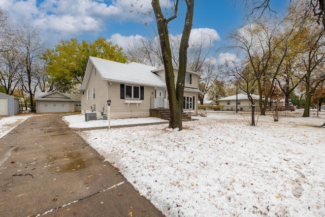 view of front of house with a garage, fence, central AC unit, and an outdoor structure