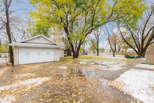 view of yard with a garage, an outdoor structure, and fence