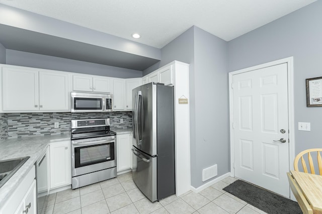 1868 Tiffany Cove Ln SW, Rochester, MN 55902 - kitchen with stainless steel appliances, light tile patterned flooring, tasteful backsplash, white cabinetry, and recessed lighting