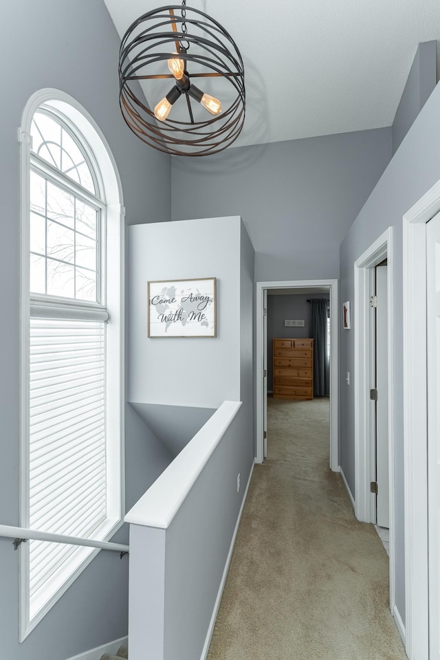 1868 Tiffany Cove Ln SW, Rochester, MN 55902 - hallway with light colored carpet, an upstairs landing, a chandelier, healthy amount of natural light, and lofted ceiling