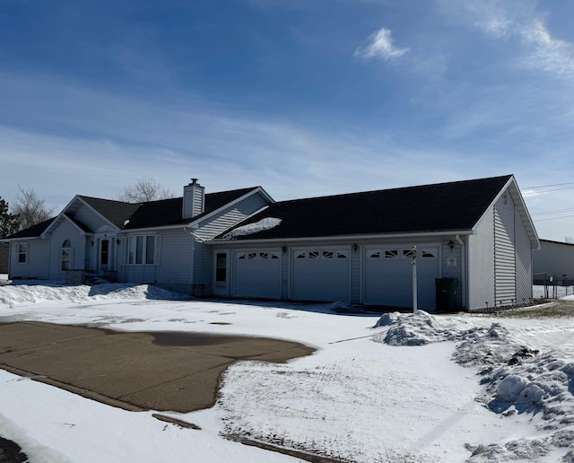 ranch-style house with a garage and a chimney