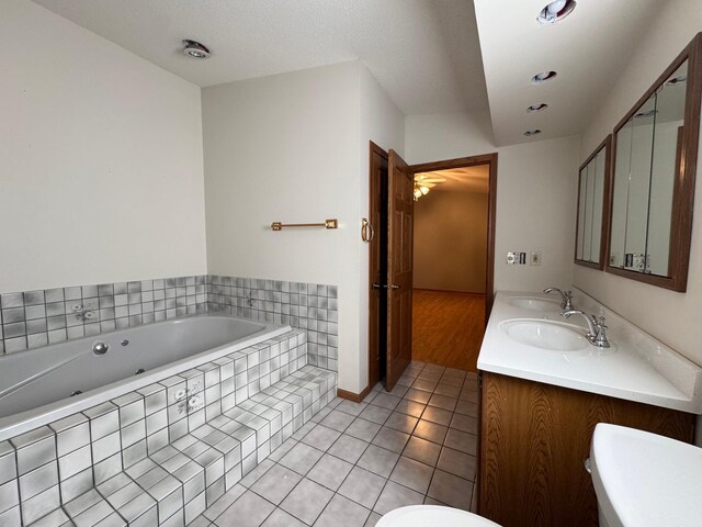 full bathroom with a bath, a sink, toilet, and tile patterned floors