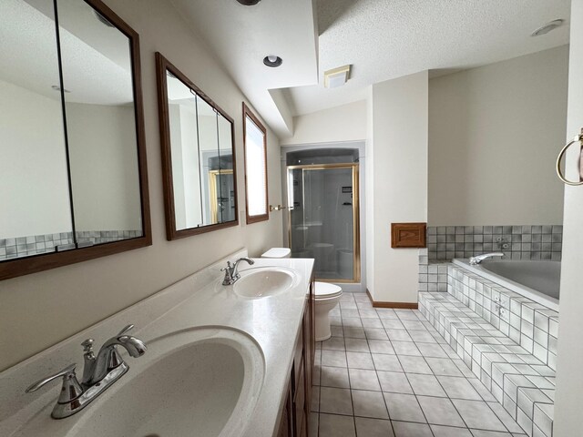 full bath featuring a garden tub, a stall shower, tile patterned flooring, and a sink