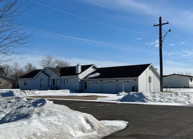 view of front facade with a garage and a chimney